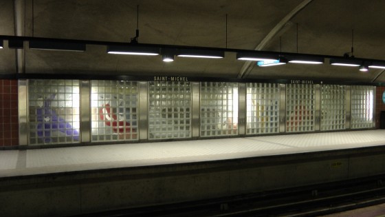 A mural by Charles Lemay behind glass brick.